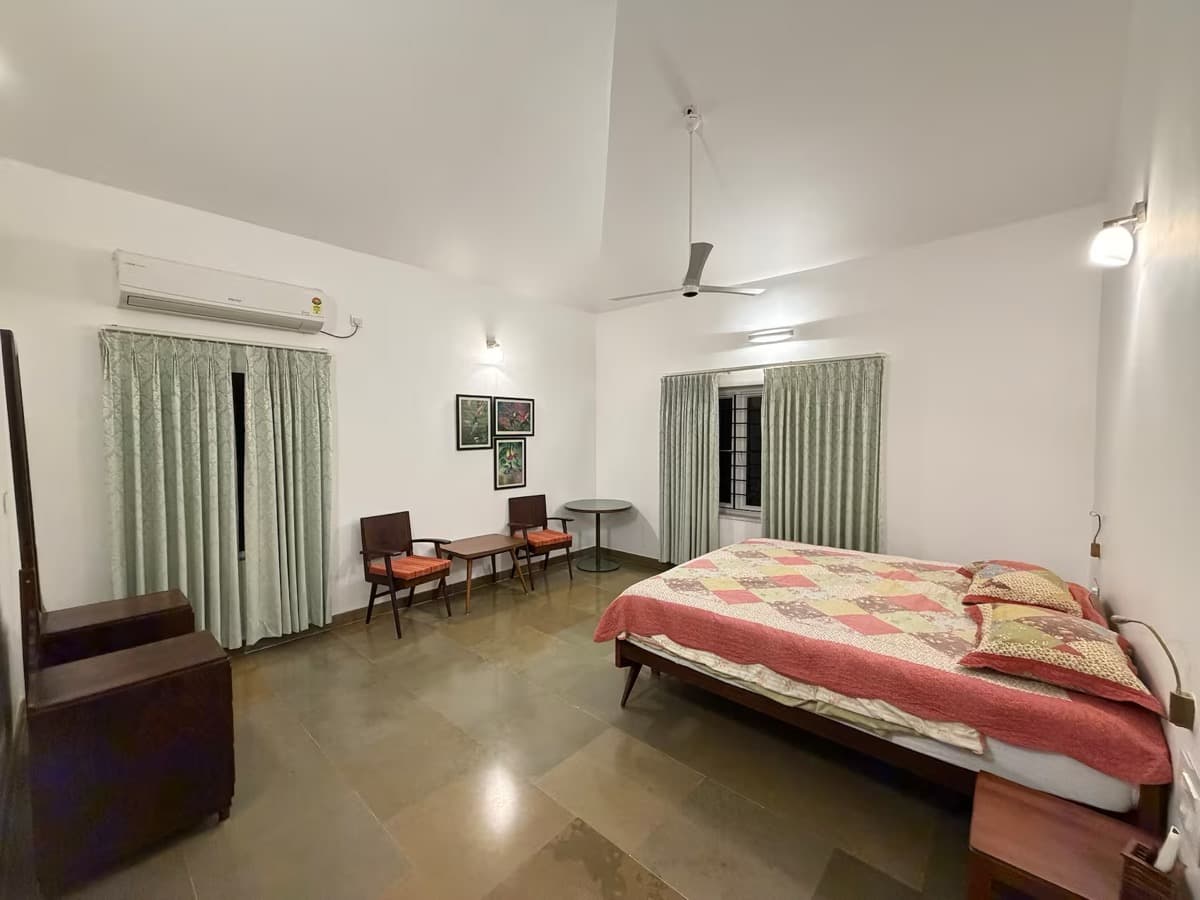 Bedroom with a patchwork quilt and seating by the window