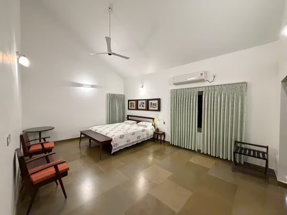 Bedroom with a double bed and lounge chairs
